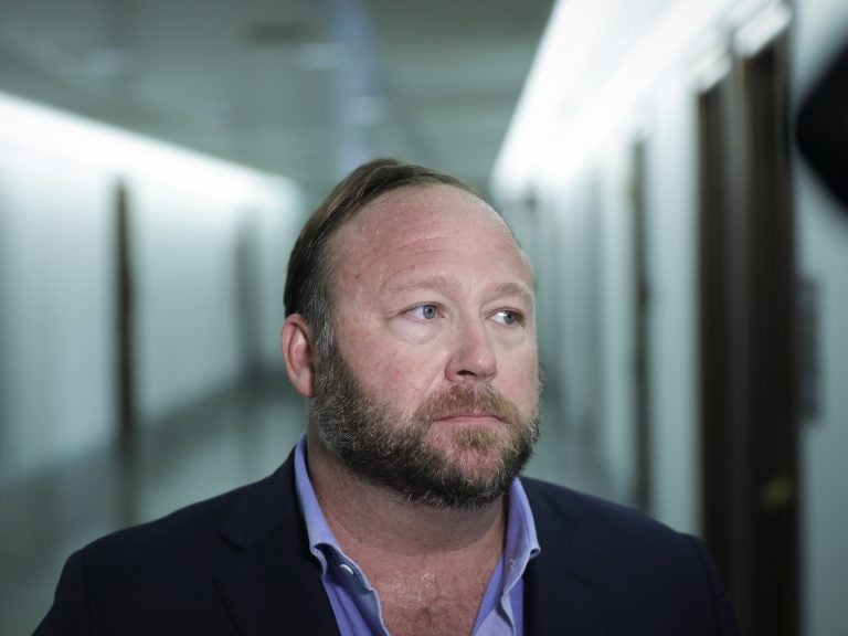 Alex Jones of InfoWars talks to reporters outside a Senate Intelligence Committee hearing on Wednesday. Twitter has permanently suspended the conspiracy theorist, citing violations of its policy on abusive behavio