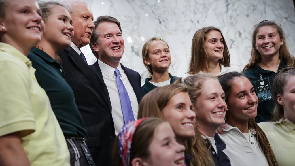 Supreme Court nominee Judge Brett Kavanaugh poses for photos with former players of the youth basketball team he coached during a break in his Senate Judiciary Committee hearings Thursday.