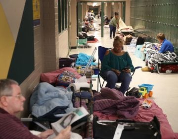 Bob Cavanagh, left, and Linda Moore, center, wait in an evacuation shelter setup at the Conway High School for the arrival of Hurricane Florence on Thursday in Conway, S.C. Many schools in the area have closed or been converted to shelters for residents in the region. (Getty)