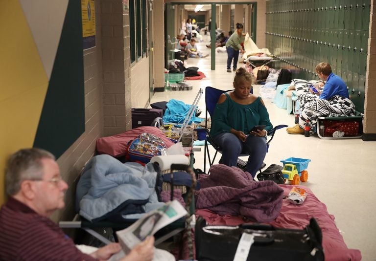Bob Cavanagh, left, and Linda Moore, center, wait in an evacuation shelter setup at the Conway High School for the arrival of Hurricane Florence on Thursday in Conway, S.C. Many schools in the area have closed or been converted to shelters for residents in the region. (Getty)