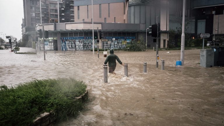 A man wades through flooded streets during a No. 10 Hurricane Signal raised for Typhoon Mangkhut in Hong Kong on Sunday. (Anthony Kwan/Bloomberg via Getty Images)