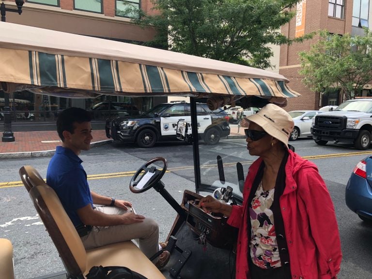 Eunice LaFate quizzes Andrew Cercena about the new golf cart taxi service he's starting for  Buccini/Pollin Group. (Cris Barrish/WHYY)