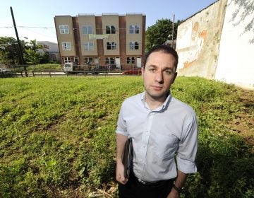 Ori Feibush, owner of ocfrealty in Philadelphia, stands on vacant lots on the 1700 block of Manton St in Point Breeze across the street from four 3-story townhouses his company built and is selling (Clem Murray/Inquirer)  