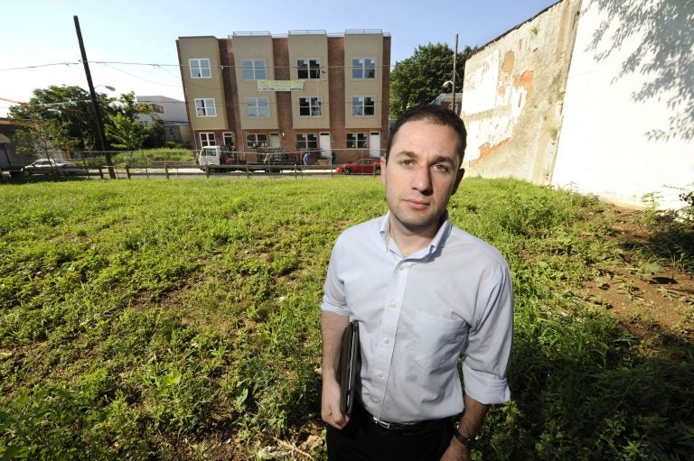Ori Feibush, owner of ocfrealty in Philadelphia, stands on vacant lots on the 1700 block of Manton St in Point Breeze across the street from four 3-story townhouses his company built and is selling (Clem Murray/Inquirer)  