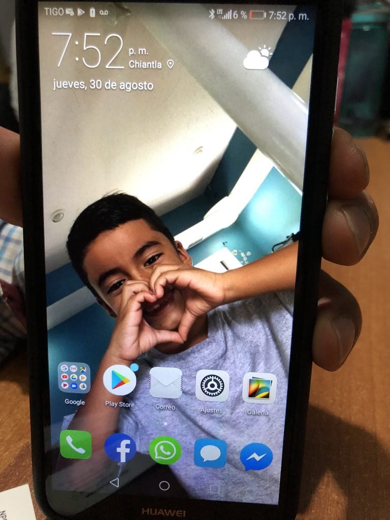 Juan Valiente Velazquez's phone shows a picture of his son, Derickson, who remains in a youth shelter in New York. They were separated by the Border Patrol in Texas in May. Velazquez was deported to Guatemala. Derickson calls his parents three times each week. (John Burnett/NPR_