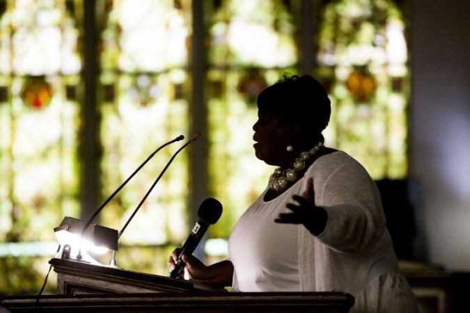 Michelle Baldwin, a member of Hickman Temple AME's praise team, leads the congregation in prayer.(Rachel Wisniewski for WHYY)