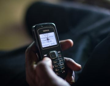 A man checks his phone to confirm that the charity GiveDirectly has transferred a cash grant to his account. (Nichole Sobecki for NPR)