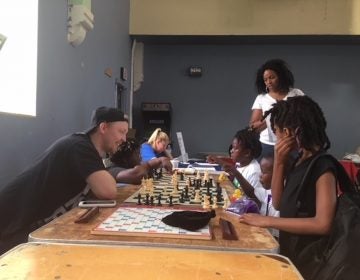 Volunteers teach young kids to play chess at the After School Activities Fair at Francis Myers Reaction Center in Southwest Philly on September 21, 2018. (Taylor Allen/WHYY)