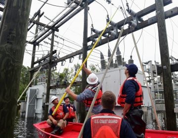 Members of the Coast Guard Shallow-Water Response team escort utility workers to a flooded substation to inspect transformers in Newport, N.C., on Sunday.