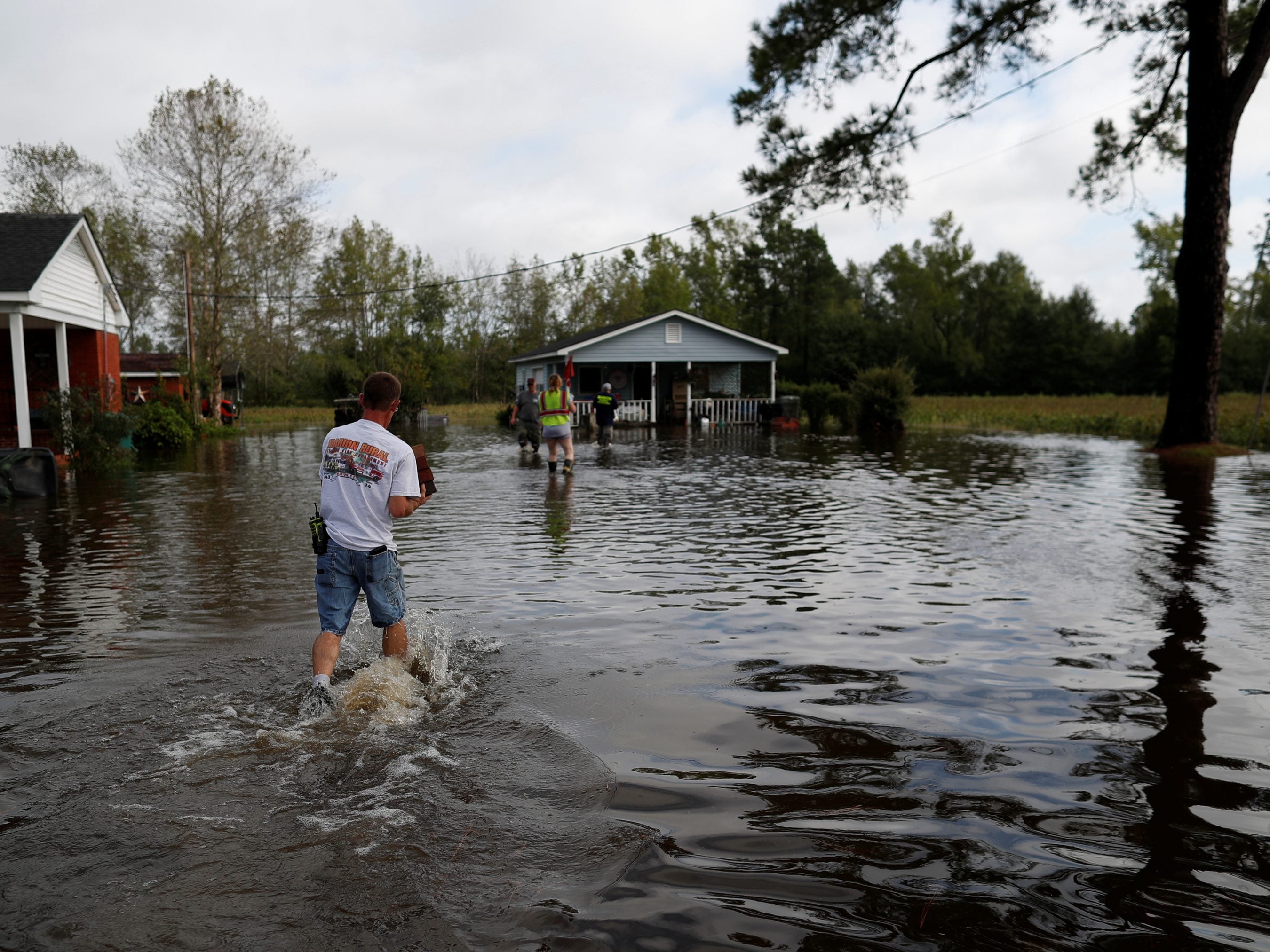 Members of the Marion Rural Fire Department hand-deliver supplies to a homeowner flooded by rains from Florence in Marion, S.C., on Monday.