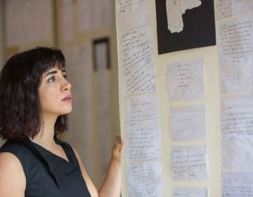 Tania El Khoury looks over letters she has received in response to her work. (Emily Cohen for WHYY)