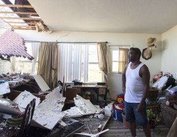 Robert Hill surveys the damage within his living room on Wednesday at Tyndall Air Force Base after Hurricane Michael hit the base last week. Support personnel from Tyndall and other bases were on location to support Airmen returning to their homes to assess damage and collect personal belongings. (Kelly Walker/U.S. Air Force)