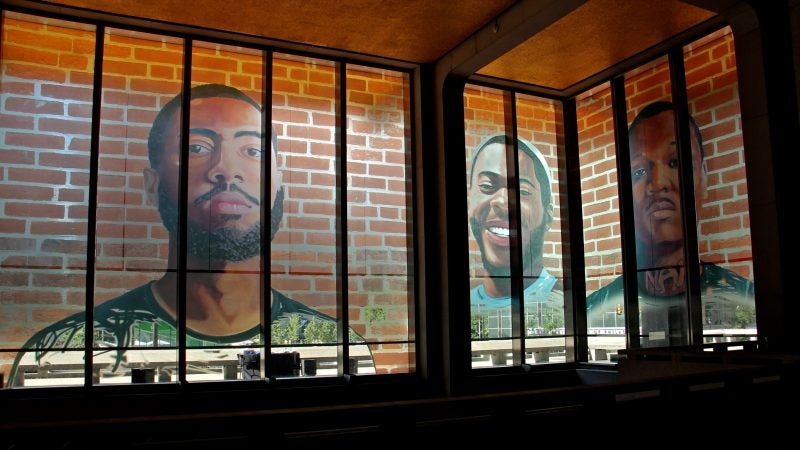 The first floor of the Municipal Services Building is wrapped with the portraits of 17 formerly incarcerated young men and women as part of the Mural Arts 