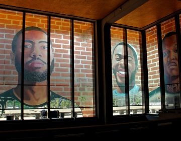 The first floor of the Municipal Services Building is wrapped with the portraits of 17 formerly incarcerated young men and women as part of the Mural Arts 