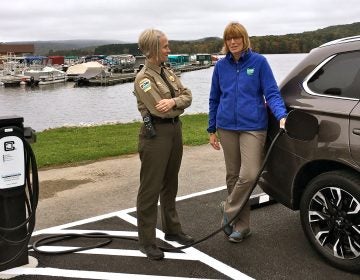 Prince Gallitzin State Park Manager Jessica Lavelua (left) and Department of Conservation and Natural Resources Secretary Cindy Adams Dunn demonstrate an electric vehicle charging station.