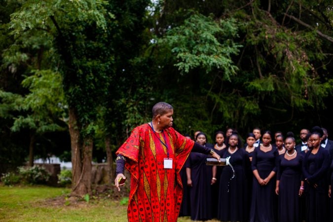 Avis Wanda McClinton pours water in memory of the dead at a memorial service for the forgotten slaves buried at Middletown Friends Meeting at Langhorne, Pa. on Saturday, Oct. 6, 2018. (Brad Larrison for WHYY)