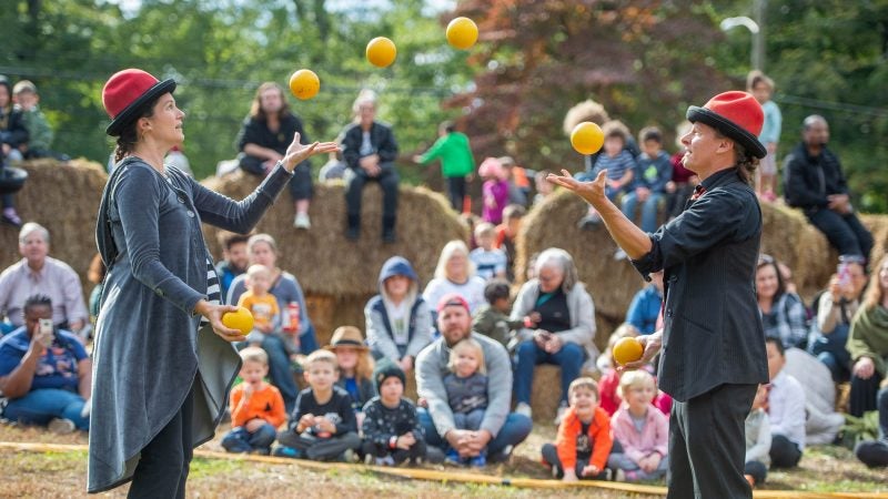 Give & Take Jugglers Allison Watman, left, and Eric Geoffrey perform for children and their parents on the lawn of the Woodmere Art Museum. (Jonathan Wilson for WHYY)