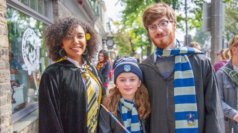 Charlene Delos Santos left, Harley Birkmire, and Joe Birkmire show off their wizard attire on Germantown Avenue. (Jonathan Wilson for WHYY)