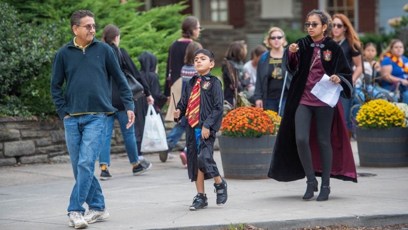 Jay Dabral, left, and his children, Sanji and Antara take in the festivities on Germantown Avenue. (Jonathan Wilson for WHYY)