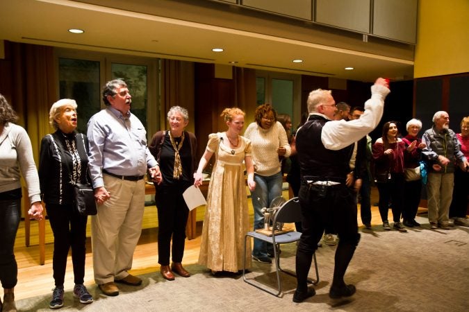 Living historians Dean Howarth and Rachel O’Connell have the audience join in a circle and share an electric shock at the Science History Institute. (Kimberly Paynter/WHYY)