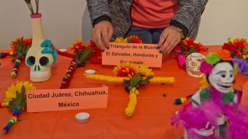 Crosses created by clients of WOAR in Philadelphia are placed on a smaller altar dedicated to victims of femicide in Central and Latin America. (Kimberly Paynter/WHYY)