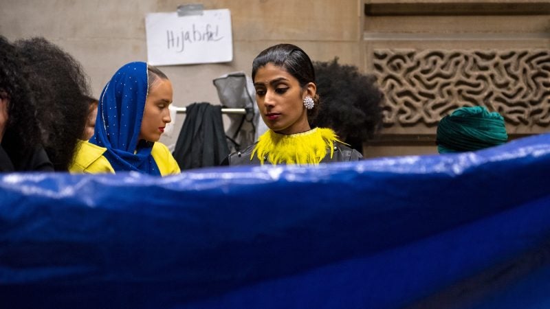 Models wait backstage as a tarp is laid out to prevent tearing at Philadelphia Fashion Week, held at Dilworth Park. (Kriston Jae Bethel for WHYY)