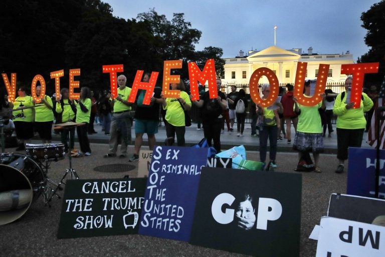 People with the group Herndon Reston Indivisible hold up letters spelling 