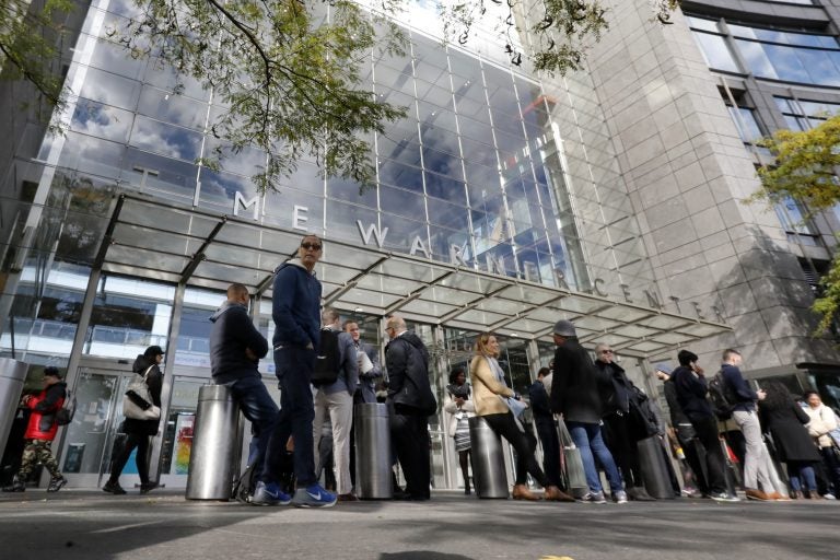 People gather outside the Time Warner Center, in New York, Wednesday, Oct. 24, 2018. A police bomb squad was sent to CNN's offices in New York City and the newsroom was evacuated because of a suspicious package. (AP Photo/Richard Drew)