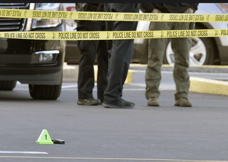 A gun lies on the ground inside a police barricade following a shooting at a Kroger grocery that left two people dead and a suspect in custody, Wednesday, Oct. 24, 2018, in Jeffersontown, Ky.  A male suspect fatally shot a man and a woman at a Kroger grocery store on the outskirts of Louisville, Kentucky, and then exchanged fire with an armed bystander before fleeing the scene, police said. He was captured shortly afterward. (AP Photo/Timothy D. Easley)