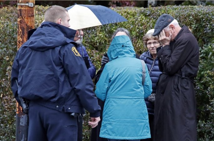 People gather on a corner near the Tree of Life Synagogue in Pittsburgh, Pa., where a shooter opened fire Saturday, Oct. 27, 2018, injuring multiple people. (Gene J. Puskar/AP Photo)