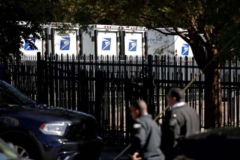 Law enforcement officials gather outside a U.S. post office facility after reports that a suspicious package was found in Atlanta, Monday, Oct. 29, 2018. (AP Photo/David Goldman)