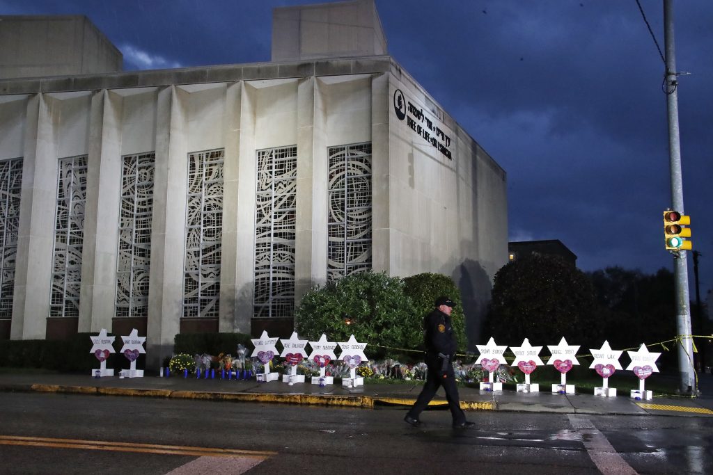 Mass Shooters Social Media In this Oct. 28, 2018, file photo a Pittsburgh Police officer walks past the Tree of Life Synagogue and a memorial of flowers and stars in Pittsburgh in remembrance of those killed and injured when a shooter opened fire during services Saturday at the synagogue. (Gene J. Puskar/AP Photo, File)