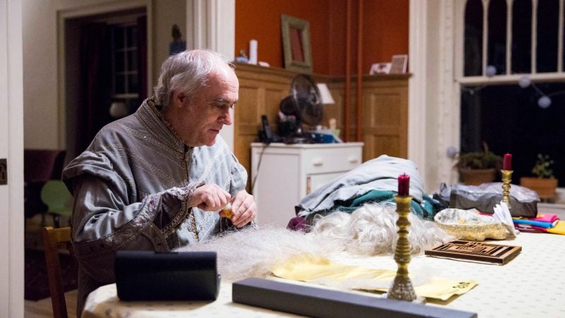 Walt Maguire surveys the costume materials he has laid out on his dining room table as he prepares to transform into the Harry Potter wizard Dumbledore on the final day of the Harry Potter festival before its legal re-brand. (Rachel Wisniewski for WHYY)