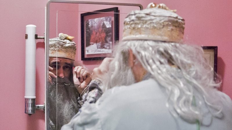 Walt Maguire adjusts his glasses in his bathroom mirror on October 20, 2017. Maguire, 60, played the part of Dumbledore at Chestnut Hill’s Harry Potter Festival for six years. Now, he is co-hosting the Witches and Wizards festival costume contest. (Rachel Wisniewski for WHYY)