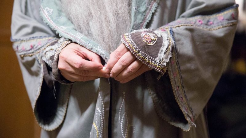 Walt Maguire puts the finishing touches on his Dumbledore costume before heading out to the Chestnut Hill Harry Potter Festival at 6 a.m. on Oct. 20. (Rachel Wisniewski for WHYY)