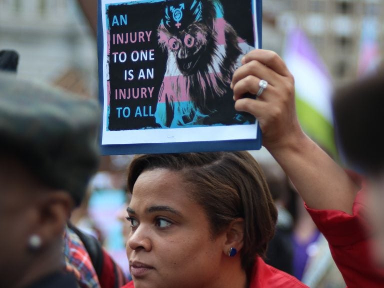 A woman holds up a sign at Tuesday's rally to protest President Trump's proposal define gender on identifiable traits at birth. (Angela M. Gervasi for WHYY)