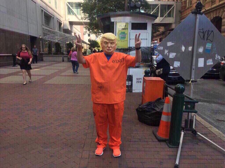 Protester dressed as Trump in a prison uniform