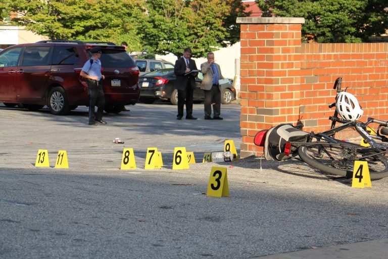 Philadelphia police investigate the scene of a multiple shooting on Germantown Avenue near Manheim Street Wednesday afternoon. Five men were shot; one later died of his injuries. (Emma Lee/WHYY)