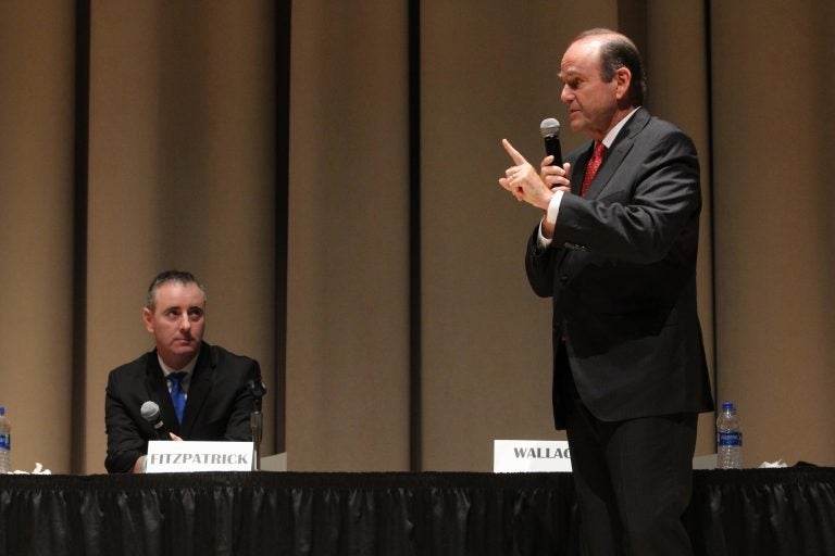 U.S. Rep. Brian Fitzpatrick, a Republican, listens to his Democratic challenger in Pennsylvania’s 1st Congressional District, Scott Wallace, during a debate at Delaware Valley University in Doylestown. (Emma Lee/WHYY)