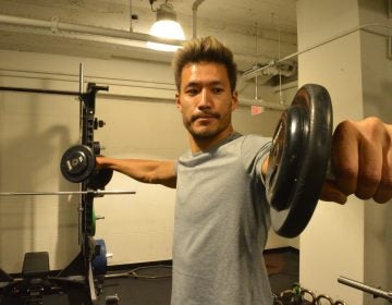 Kevin Kreider, a model and former bodybuilder, lifts weights at his local gym. Kreider says he quit pre-workout after becoming addicted. (Liz Tung/WHYY)