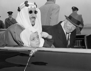 Six-year-old Prince Mashhur ibn Saud waves as he sits on the lap of his father, King Saud of Saudi Arabia, and beside President Eisenhower as they left National Airport, January 30, 1957.  The King and his official party will visit here three days for talks with the President.  (AP Photo)