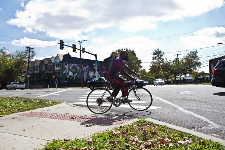 A cyclist tentatively rolls into the street at Belmont and Parkside Avenues. (Kimberly Paynter/WHYY)