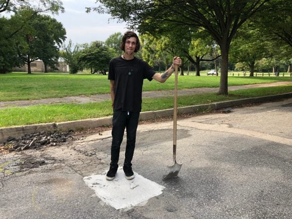 Skater Dickey Johnston stands on a pothole at FDR Park he helped repair. (Meir Rinde for WHYY)