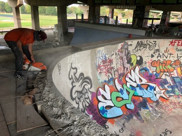 A skater cuts concrete around a bowl at the skatepark in FDR Park. (Meir Rinde for WHYY)