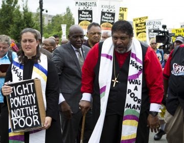 The Rev. William Barber marches outside the U.S. Capitol during a Poor People's Campaign rally in June. On the left is co-leader of the Poor People's Campaign, the Rev. Liz Theoharis. (Jose Luis Magana/AP)