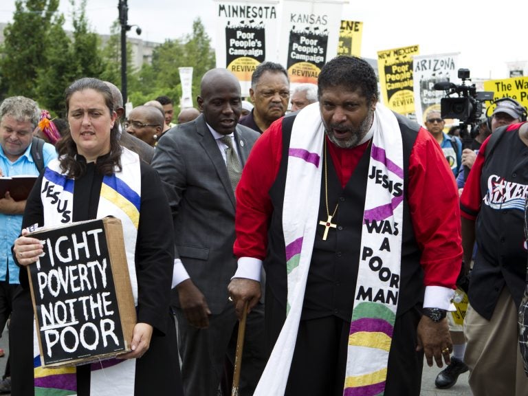 The Rev. William Barber marches outside the U.S. Capitol during a Poor People's Campaign rally in June. On the left is co-leader of the Poor People's Campaign, the Rev. Liz Theoharis. (Jose Luis Magana/AP)