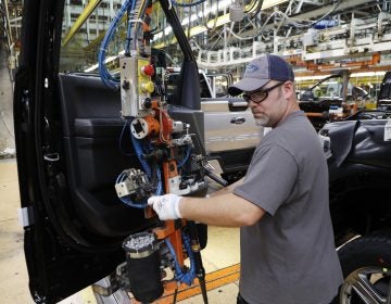 A worker installs a door on a 2018 Ford F-150 truck at an assembly plant in Dearborn, Mich., on Sept. 27. The U.S. unemployment rate fell to 3.7 percent in September, a nearly 50-year low. (Carlos Osorio/AP)