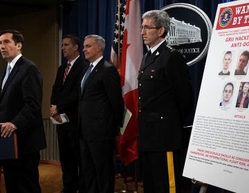 Assistant U.S. Attorney General for National Security John C. Demers, (left), speaks as U.S. Attorney for the Western District of Pennsylvania Scott W. Brady, 3rd from (left), FBI Deputy Assistant Director for Cyber Division Eric Welling, 2nd from (left), and Director General Mark Flynn, (right), for the Royal Canadian Mounted Police listen during a news conference to announce criminal charges Thursday.
(Alex Wong/Getty Images)