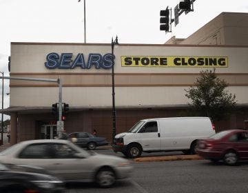 A sign announcing a store closing hangs above a Sears in Chicago. The bankruptcy filing could mark the end of the struggling retailer, which invented the mail-order catalog busines