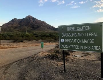 A sign outside Ajo, Ariz., warns hikers to keep an eye out for people who have unlawfully crossed the nearby border with Mexico. (Ryan Lucas/NPR)